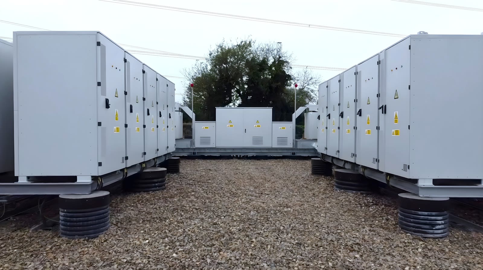 Rows of containerized battery energy storage units on a gravel site
