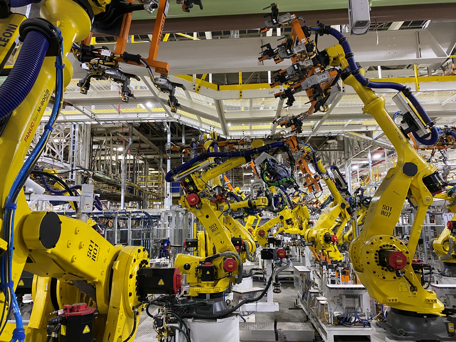 Overhead robotic welding arms on an active automotive assembly line