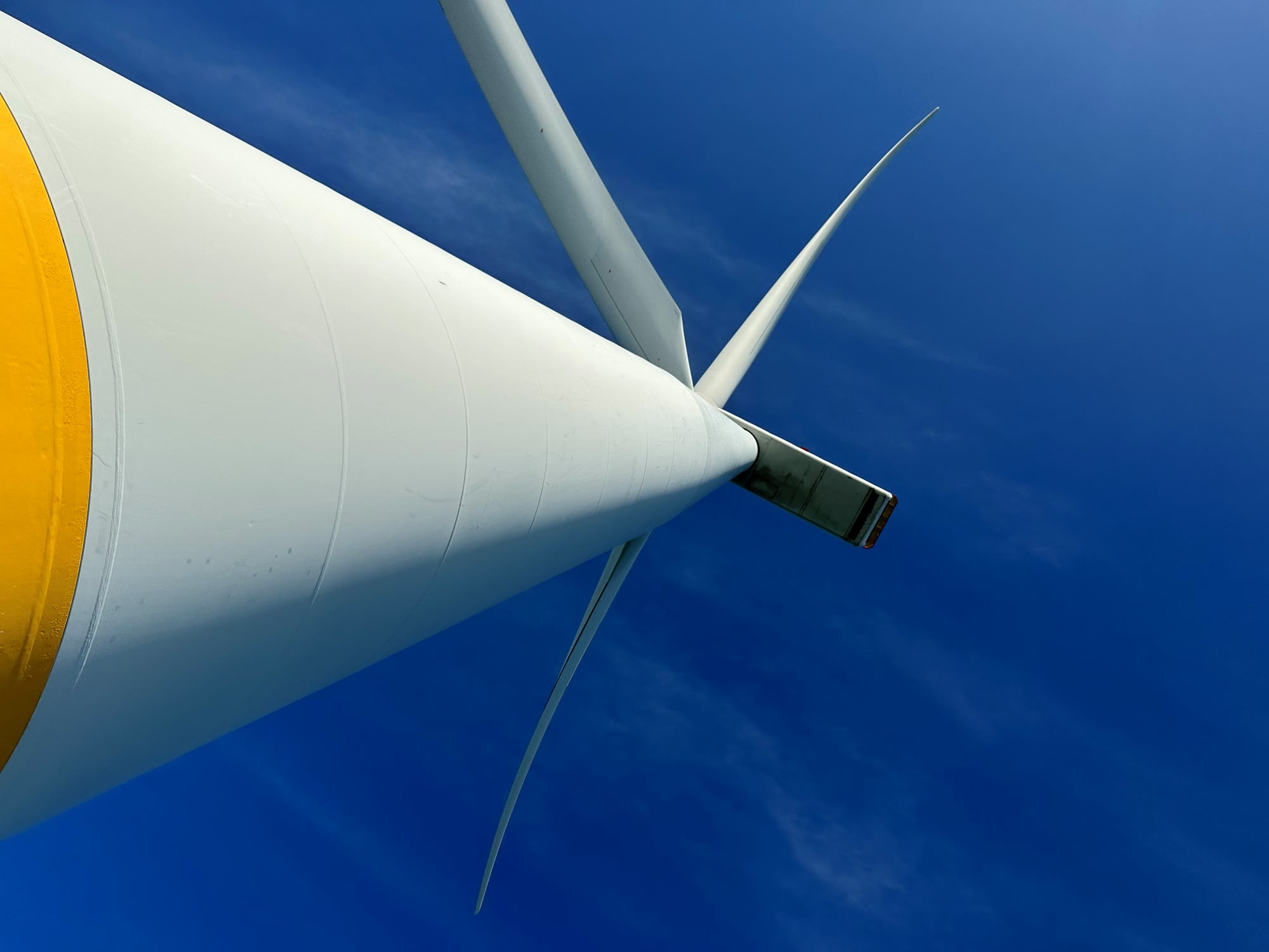 Looking up the tower of an offshore wind turbine at its nacelle and blades